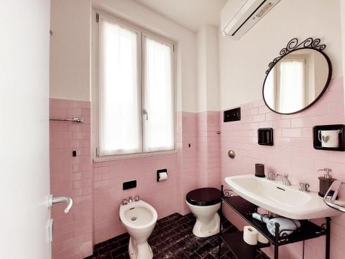 a pink bathroom with a toilet and a sink at Agriturismo Conca Sandra - Farm Stay on Lake Como in Perledo