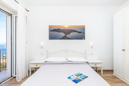 a bedroom with a bed, desk, and a painting on the wall at Tramonto sul mare in Santa Teresa Gallura