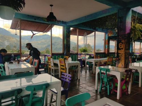 a man standing in a restaurant with tables and chairs at El Patio de mi Casa Hotel Restaurante in Salento