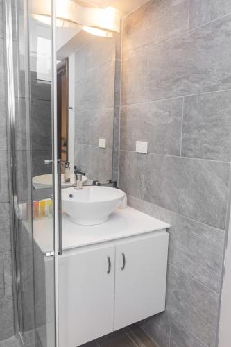 a bathroom with a white sink and a mirror at Tradewinds Apartments Simpson Bay in Simpson Bay