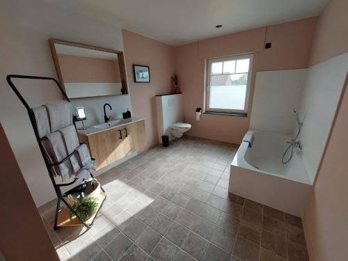 a bathroom with a tub and a toilet and a sink at B&B Hope & Anchor in Averbodeheide