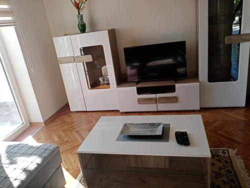 sala de estar con TV y mesa de centro en Apartmani Bosco, en Tivat