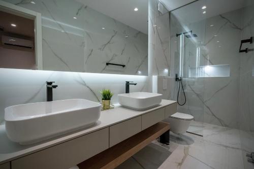 een witte badkamer met 2 wastafels en een douche bij Amélie Luxury Rooms in Split