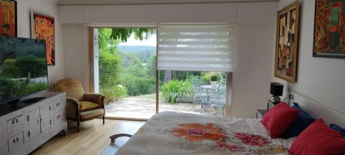 una camera da letto con un letto e una porta scorrevole in vetro di Villa d'exception piscine & domaine privé Mougins a Mougins