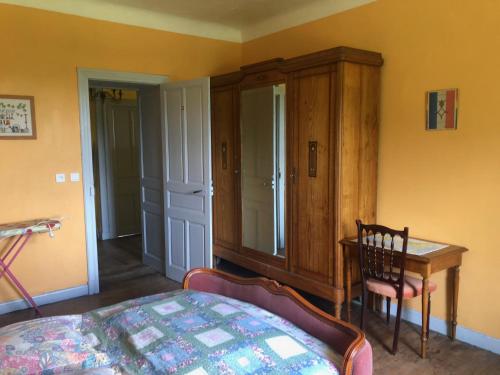 a bedroom with a bed and a desk and a cabinet at Un écrin dans la nature in Espelette