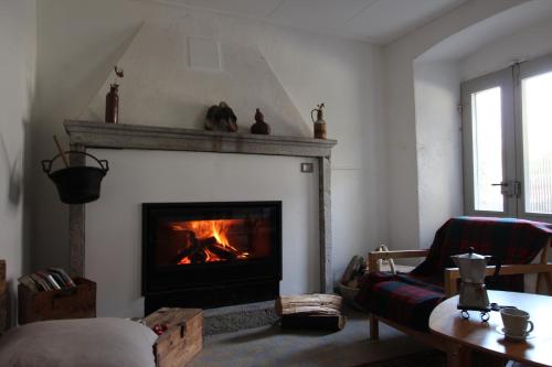 Casa Eva في Brione: غرفة معيشة مع موقد نار