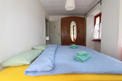 a large bed with two green pillows on it at Casa Eva in Brione