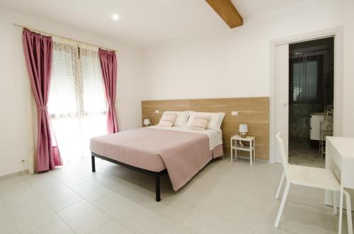 a white bedroom with a bed and a bathroom at B&b la Casa dei Nonni in Silvi Paese