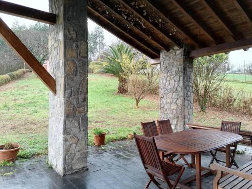 a wooden table and chairs on a patio at La casa azul de Lua Un lugar mágico in Juncedo-Campo