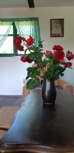 a vase with red roses sitting on a table at Bakina iža in Duga Resa