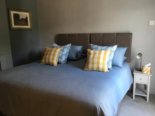 a bedroom with a bed with blue and yellow pillows at The One @ West End in West Haddon