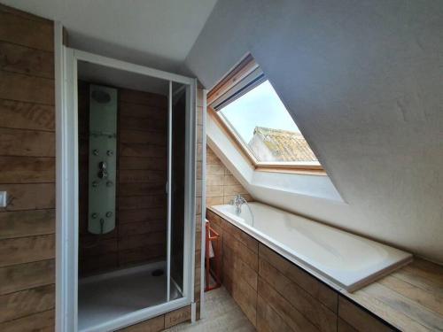 uma casa de banho com uma banheira e uma janela em Charmant appartement proche commerces et plages em Le Guilvinec