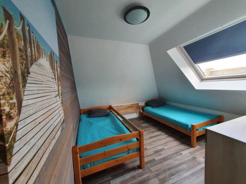um quarto com duas camas e uma janela em Charmant appartement proche commerces et plages em Le Guilvinec