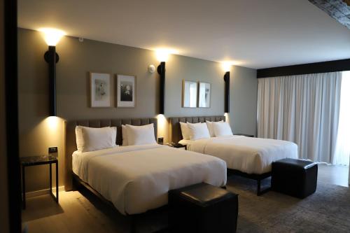 2 camas en una habitación de hotel con luces encendidas en Bellwort Hotel en Guadalajara