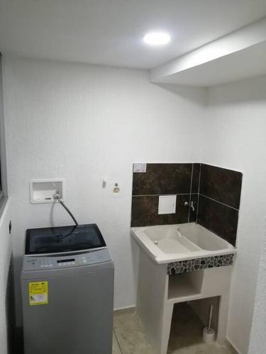 a small bathroom with a sink and a counter at Apartamento confortable de lujo in Cartago