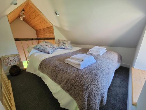 a bedroom with a bed with towels on it at Cae Hedd Holiday Cottages in the heart of Monmouthshire in Llanfaenor