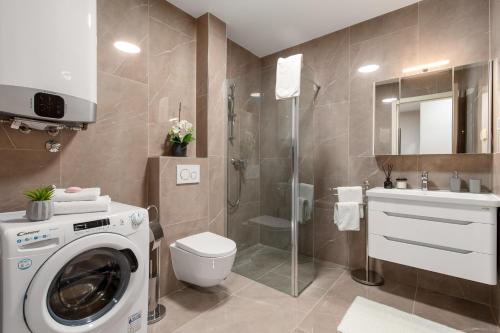 uma casa de banho com uma máquina de lavar roupa e um chuveiro em Apartment HANA em Pjescana Uvala