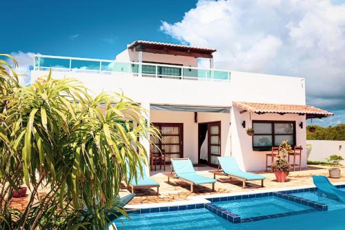 a villa with a swimming pool and blue chairs at Qavi - Leuchtturm House #ParaisoDoBrasil in Parnamirim