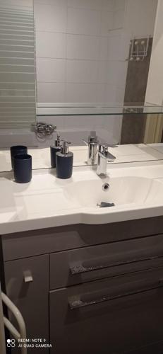 une salle de bain avec un lavabo blanc et un miroir dans l'établissement Superbe T3 climatisé calme Marina canet 2 min de la plage, à Canet