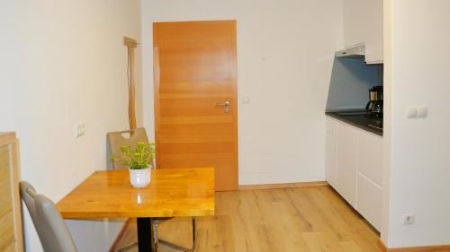 a small kitchen with a table and a wooden door at Residence Ferienwohnungen Sonnegg in Vollan