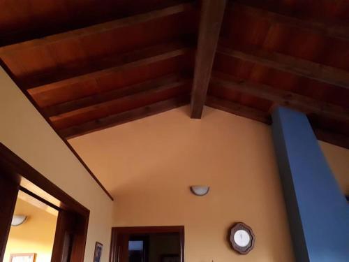 a room with a wooden ceiling with a clock on it at La casa azul de Lua Un lugar mágico in Juncedo-Campo