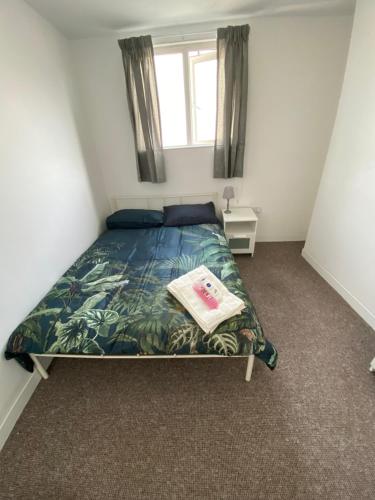 Dormitorio pequeño con cama con colcha y almohada en The White Room, en Plymouth