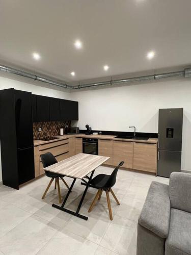 une cuisine avec une table et des chaises dans une pièce dans l'établissement Belle appartement avec parking gratuit, à Blanzy