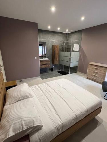 une chambre avec un grand lit et une salle de bain dans l'établissement Belle appartement avec parking gratuit, à Blanzy