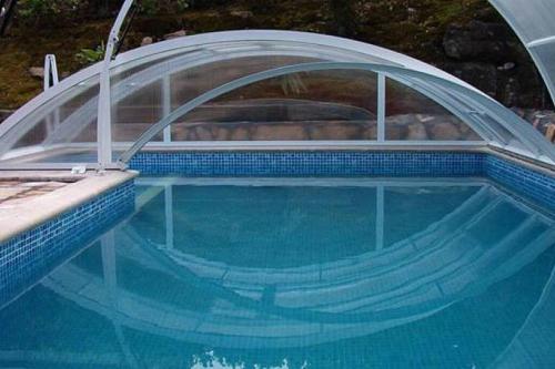 einen Pool mit einer Abdeckung über dem Wasser in der Unterkunft casa a 50 metros de playa con piscina cubierta in Liencres