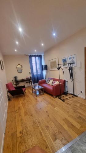 un salon avec un canapé rouge et une table dans l'établissement Appartement en plein cœur de vieille Nice, à Nice