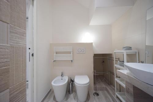 bagno bianco con servizi igienici e lavandino di Ghisello Luxury Guesthouse a Bologna