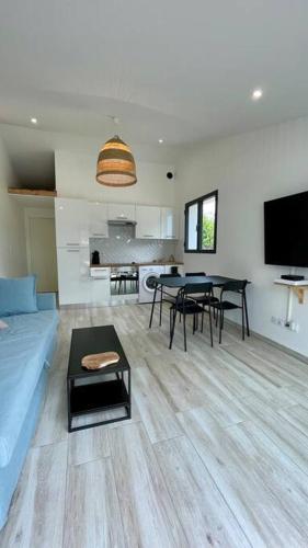 un salon avec un canapé bleu et une table dans l'établissement Maisonnette chaleureuse a proximité du centre, à Narbonne