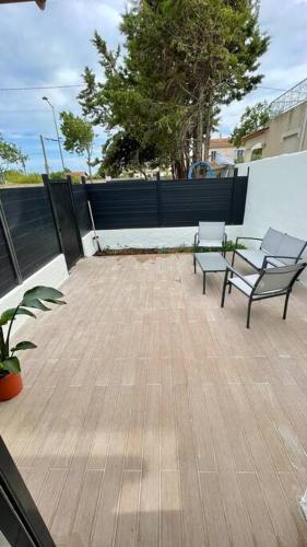 un patio avec deux bancs et une clôture dans l'établissement Maisonnette chaleureuse a proximité du centre, à Narbonne