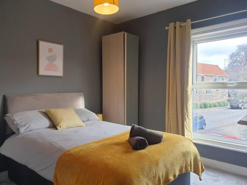 a bedroom with a bed with a yellow blanket and a window at Cosy 2 Bedroom City House with 2 Bathrooms in Norwich