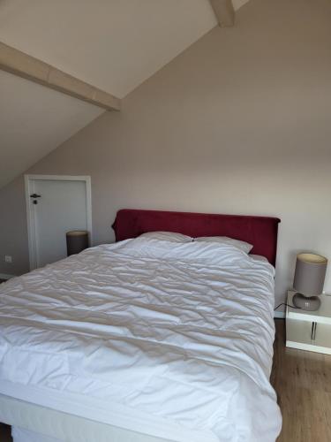 ein weißes Bett mit einem roten Kopfteil in einem Schlafzimmer in der Unterkunft Beautiful property in front of Annecy Lake in Veyrier-du-Lac