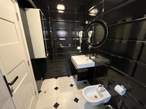 a black and white bathroom with a sink and a mirror at Bella Vista B&B in Ulcinj