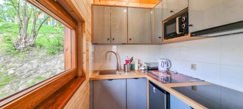 a small kitchen with a sink and a window at Domki Na Szlaku Bieszczady in Uherce Mineralne (7)