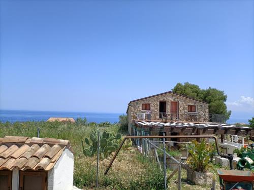 an old house on a hill next to the ocean at Casolare La Torre in Scopello
