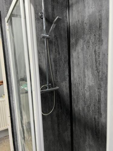 a shower with a hose on a wall at Nuns Moor fully equipped kitchen free parking Netflix in Newcastle upon Tyne
