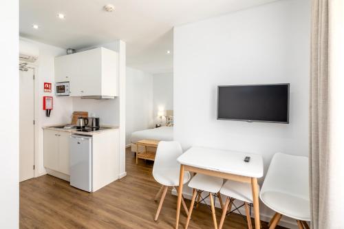 a studio apartment with a kitchen and a bedroom at Hotel Cidade de Olhão in Olhão