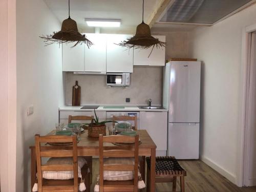 a kitchen with a table with chairs and a refrigerator at CASA SIETE LAGOS in Sinlabajos