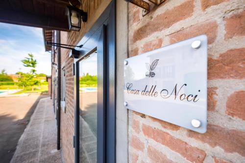 a sign on the side of a brick building at Casa delle Noci country house, pool & SPA in Modena