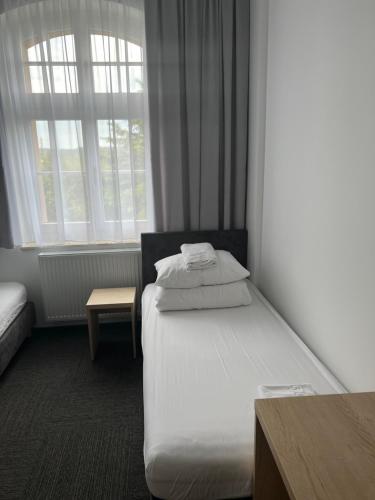 a hotel room with a bed and two windows at DOMUS MARIAE Gietrzwałd in Gietrzwałd