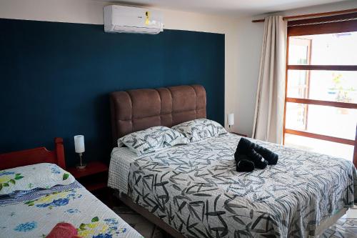 a bedroom with a bed with a stuffed animal on it at Qavi - Leuchtturm House #ParaisoDoBrasil in Parnamirim