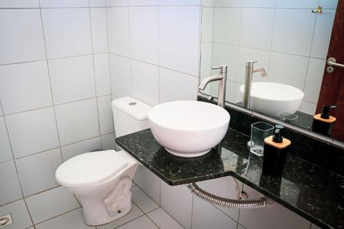a white bathroom with a toilet and a sink at Qavi - Leuchtturm House #ParaisoDoBrasil in Parnamirim