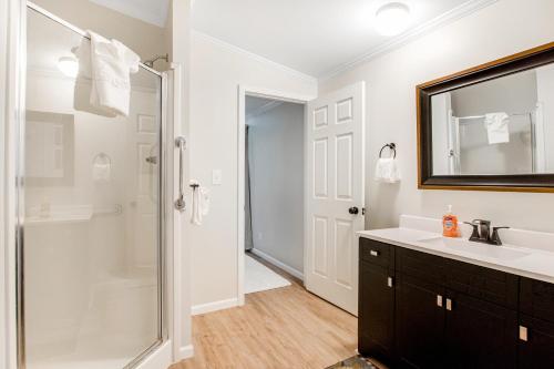 La salle de bains est pourvue d'une douche, d'un lavabo et d'un miroir. dans l'établissement Wildwood by the Lake, à Mauston