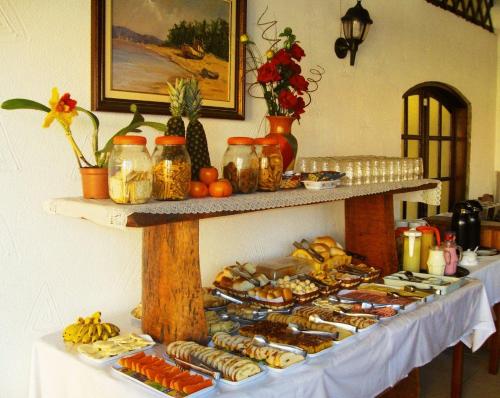 a table with a buffet of food on it at Peruíbe Suíte Flat Hotel in Peruíbe