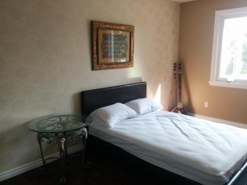 a bedroom with a bed and a glass table at Mac B&B in Ottawa