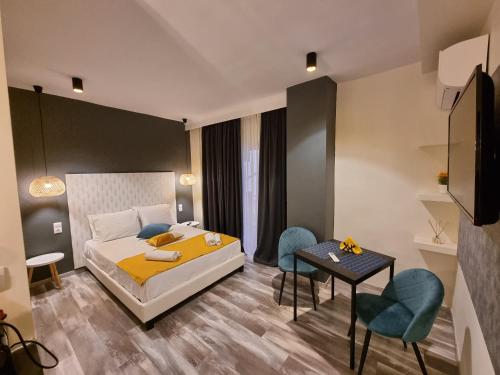 um quarto com uma cama, uma mesa e cadeiras em City Space Suites em Giannitsá