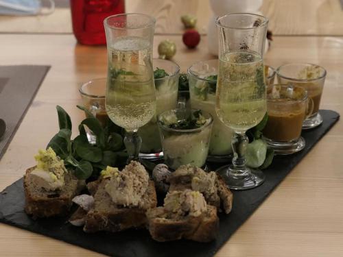 un piatto di cibo e bicchieri di vino su un tavolo di Val d Azur B C a Molines-en-Queyras